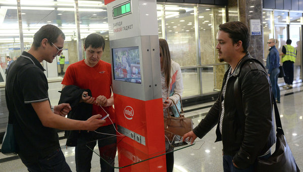 Пассажиры Московского метрополитена заряжают мобильные гаджеты у специального стенда на станции Выставочная. Архивное