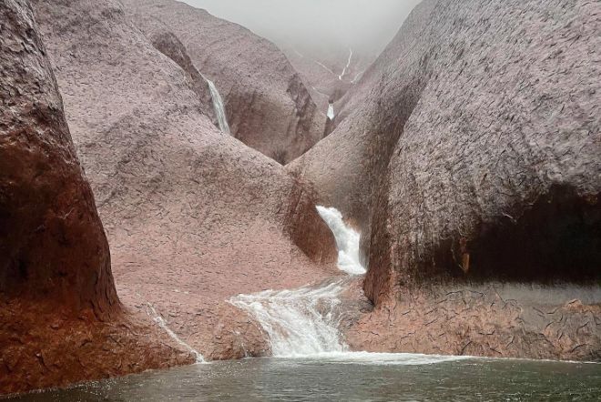 водопады улуру, видео водопадов улуру, фотографии водопадов улуру, водопады каскадом спускаются вниз по Улуру, поскольку суровая погода приносит проливные дожди на Северную территорию в Австралии