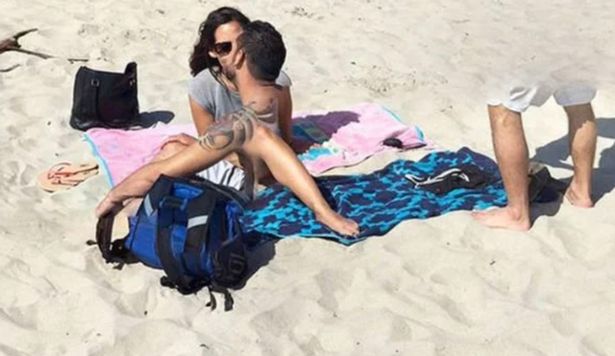 Причудливое фото мужчины и женщины, целующихся на пляже, на Google Картах, рядом с другим человеком.