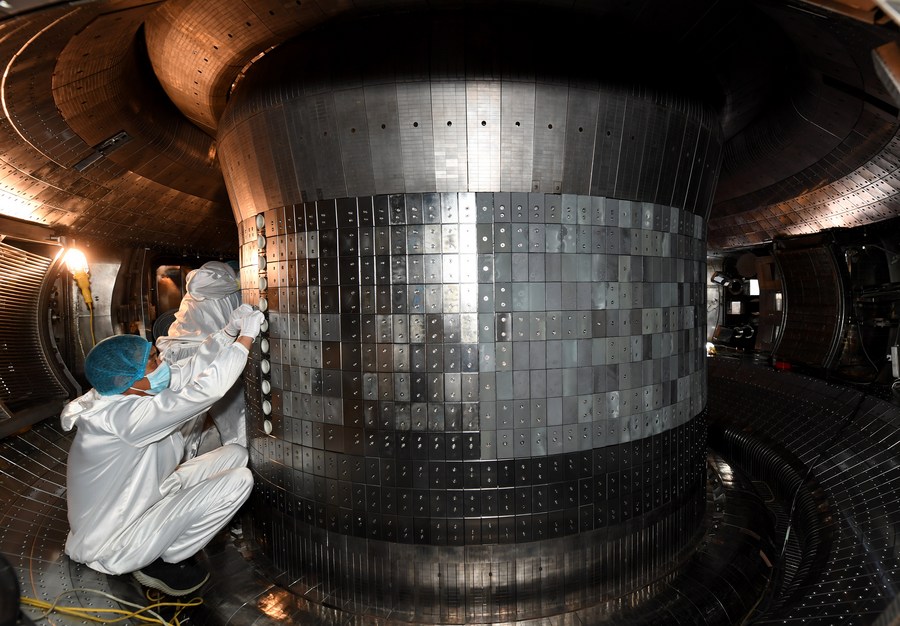 Ученые работают внутри экспериментального усовершенствованного сверхпроводящего токамака. Предоставлено: Синьхуа / Лю Цзюньси.