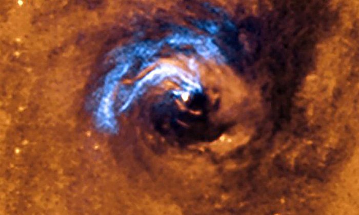 На изображении показан процесс ядерной подпитки черной дыры в галактике NGC 1566 и то, как пылевые волокна, окружающие активное ядро, захватываются и вращаются по спирали вокруг черной дыры, пока она не поглотит их. Предоставлено: ESO.