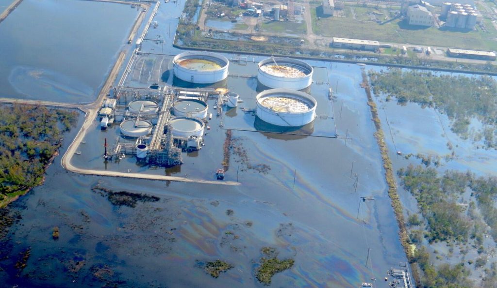 большой маслянистый блеск в паводковых водах, окружающих часть нефтеперерабатывающего завода Alliance около Belle Chasse. Нефтеперерабатывающий завод затопил сразу после того, как ураган Ида обрушился на побережье Луизианы. 