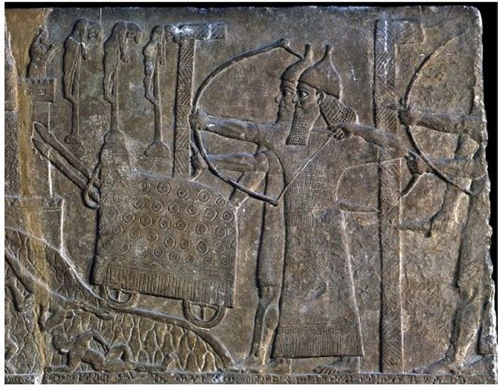 Сцена осады с двумя массивными L-образными щитами, защищающими ассирийских солдат, на рельефе из дворца Тиглатпилесар III в Нимруде (любезно предоставлено Британским музеем
