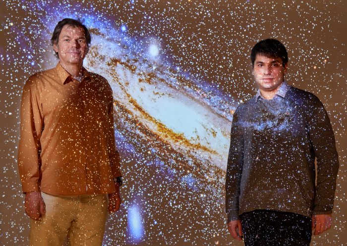 Проф. д-р Павел Крупа (слева) и Мориц Хасльбауэр (справа) — с проекцией галактики Андромеды. Предоставлено: Фолькер Ланнерт/Боннский университет.